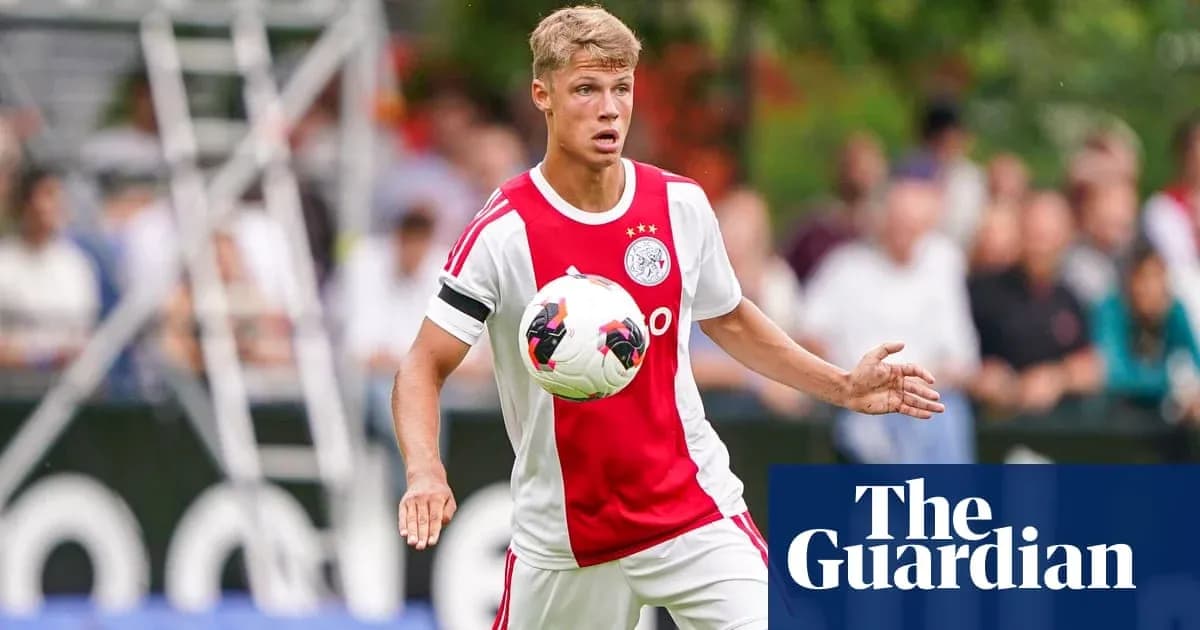 Player in Ajax kit controlling the ball during match Player in Ajax kit controlling the ball during match