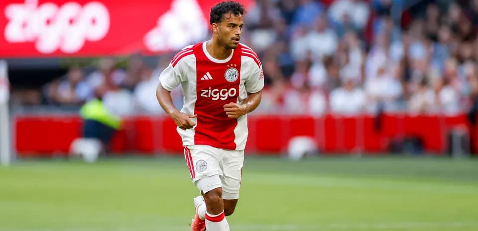 Player in Ajax kit running on the pitch Player in Ajax kit running on the pitch