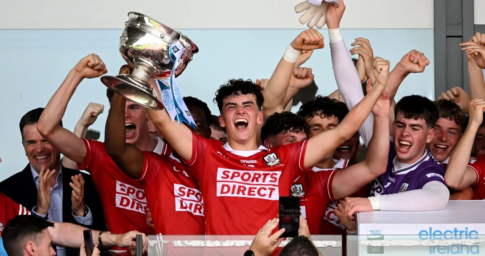 Team celebrating victory with trophy in hand Team celebrating victory with trophy in hand