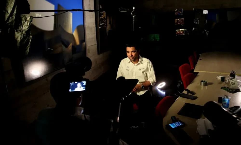 Person being interviewed in a dimly lit room Person being interviewed in a dimly lit room
