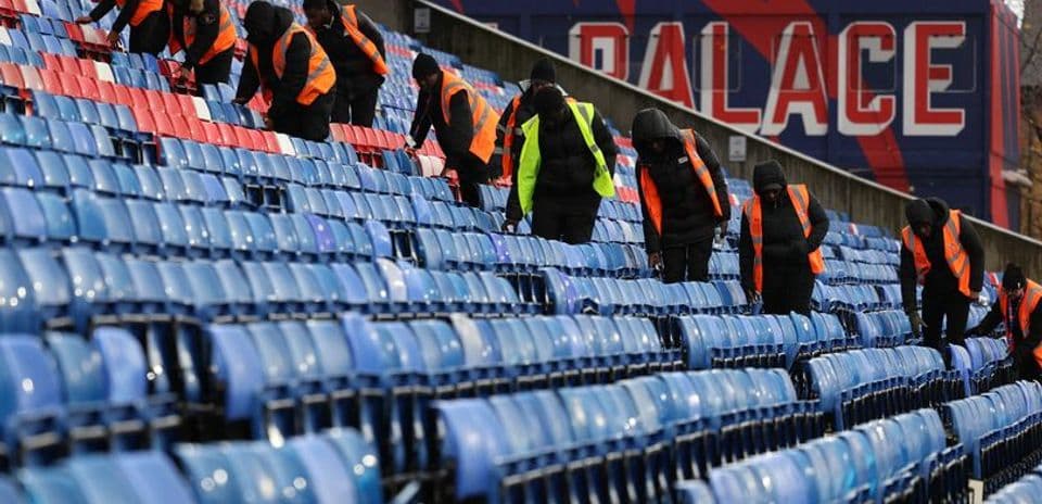 Staff cleaning seats at stadium before event Staff cleaning seats at stadium before event