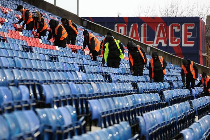 Staff cleaning seats at stadium before event Staff cleaning seats at stadium before event