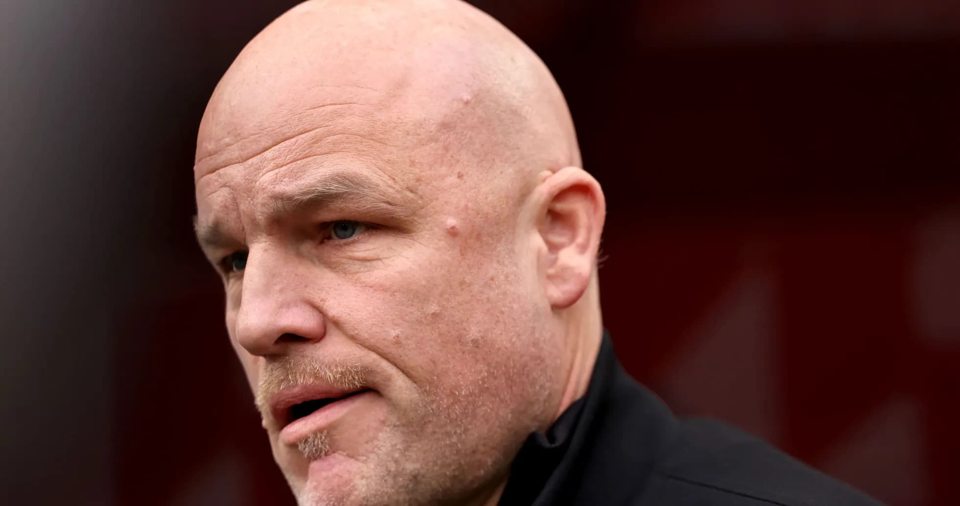 Bald man speaking in a sports setting Bald man speaking in a sports setting