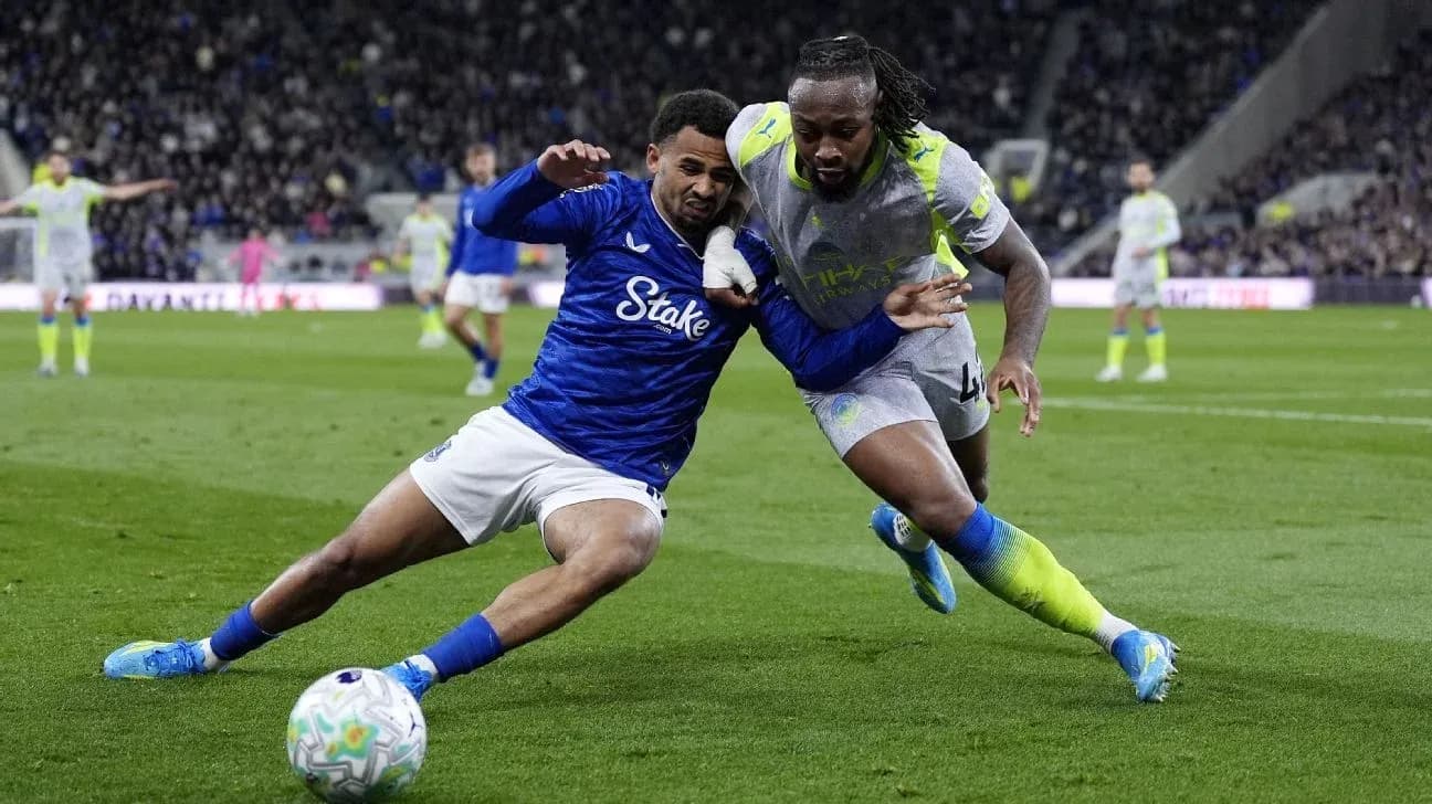 Two players battling for the ball on the field Two players battling for the ball on the field