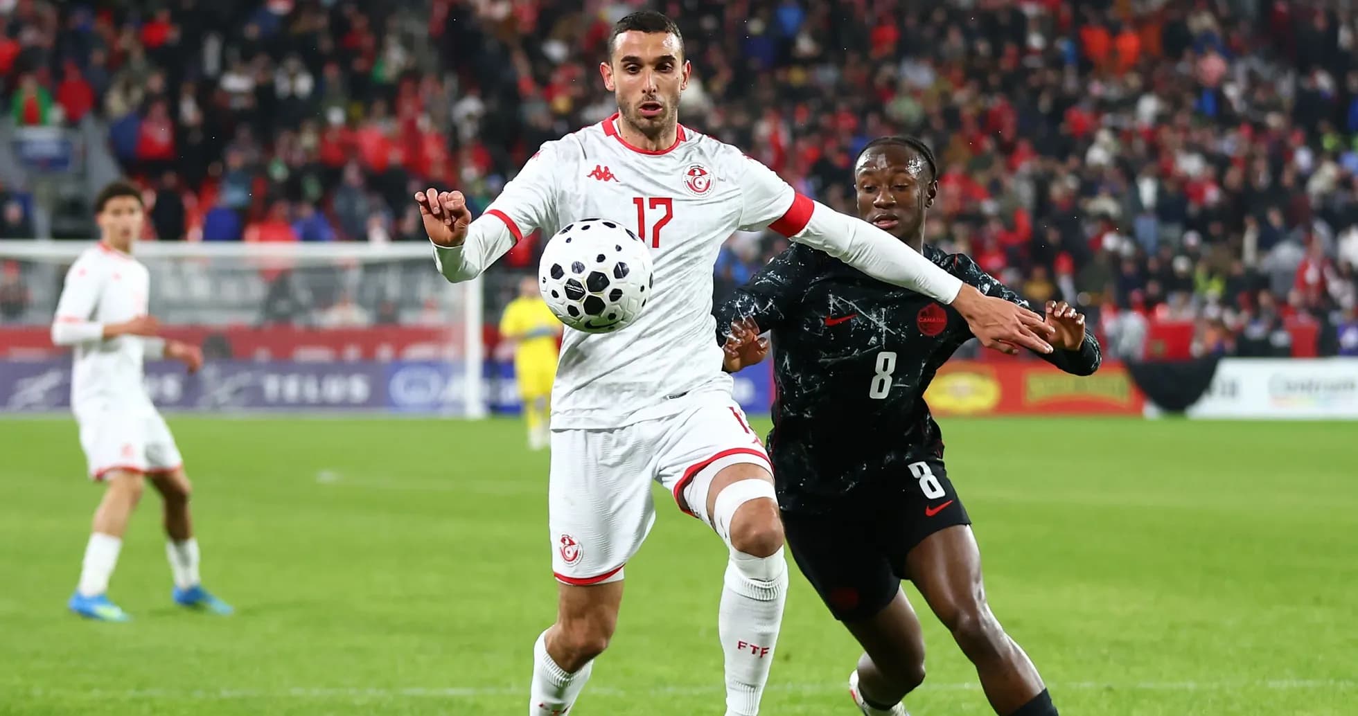 Tunisian player controlling ball while being challenged Tunisian player controlling ball while being challenged