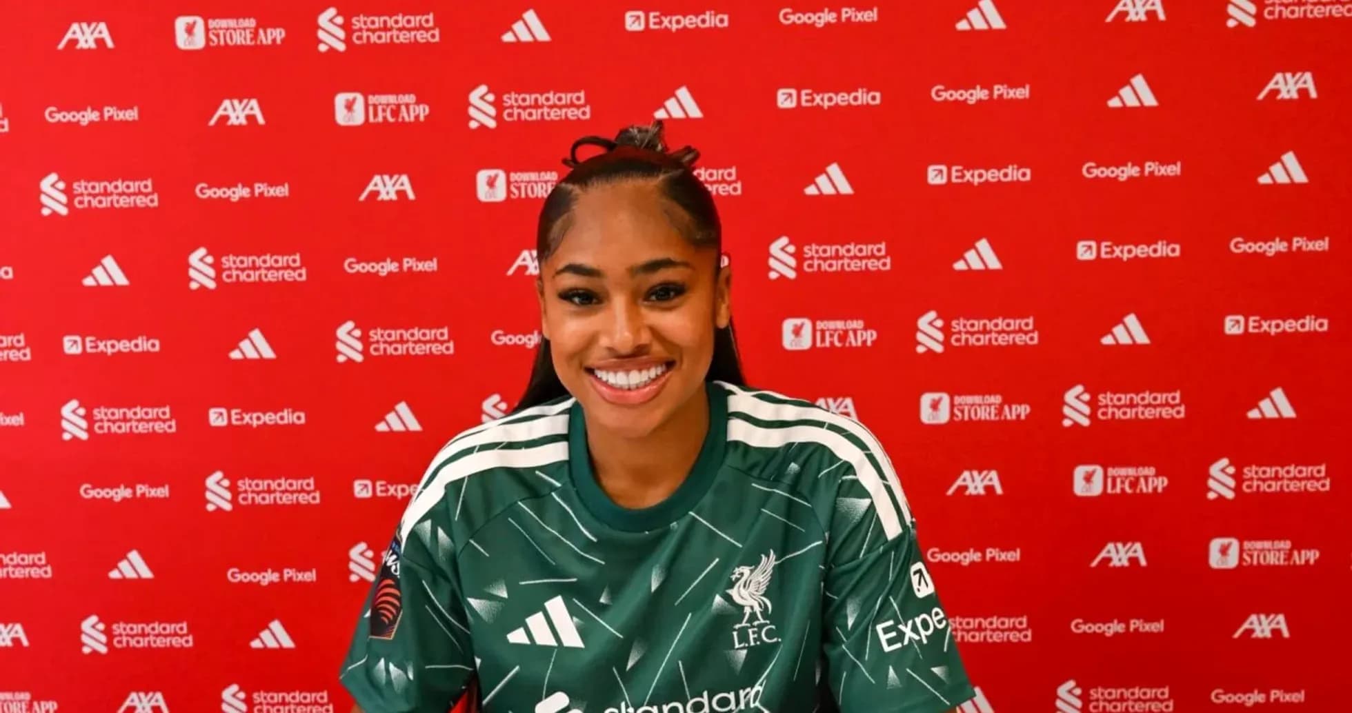 Player smiling during press conference with Liverpool backdrop Player smiling during press conference with Liverpool backdrop