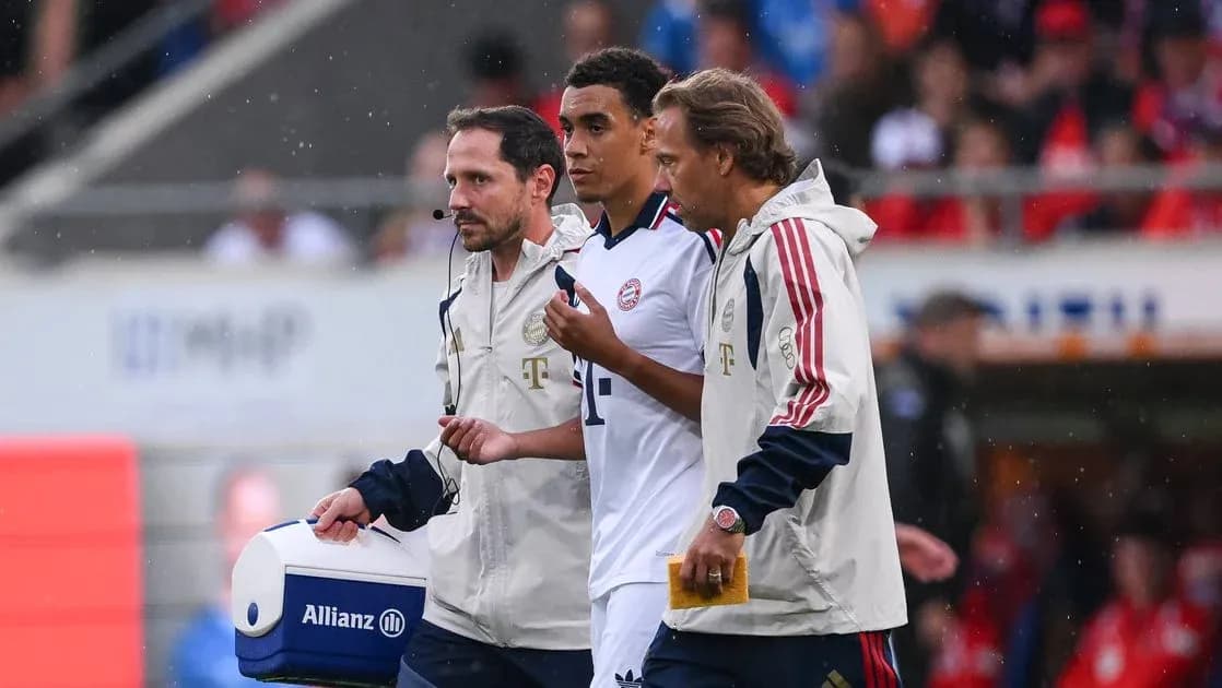 Player being assisted off field by staff members Player being assisted off field by staff members