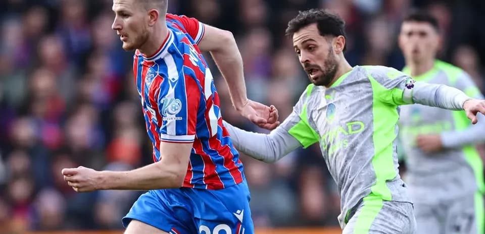 Crystal Palace player challenged by Manchester City opponent Crystal Palace player challenged by Manchester City opponent