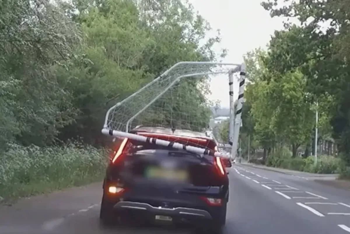 Car transporting a soccer goal on a road Car transporting a soccer goal on a road