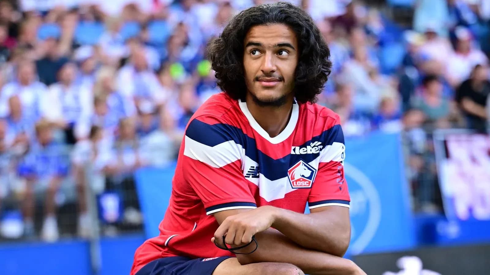 Player in LOSC Lille jersey sitting on field Player in LOSC Lille jersey sitting on field