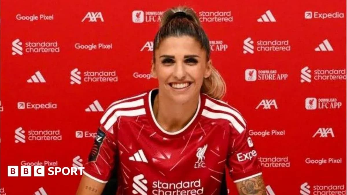 Player smiling in Liverpool jersey at press conference Player smiling in Liverpool jersey at press conference