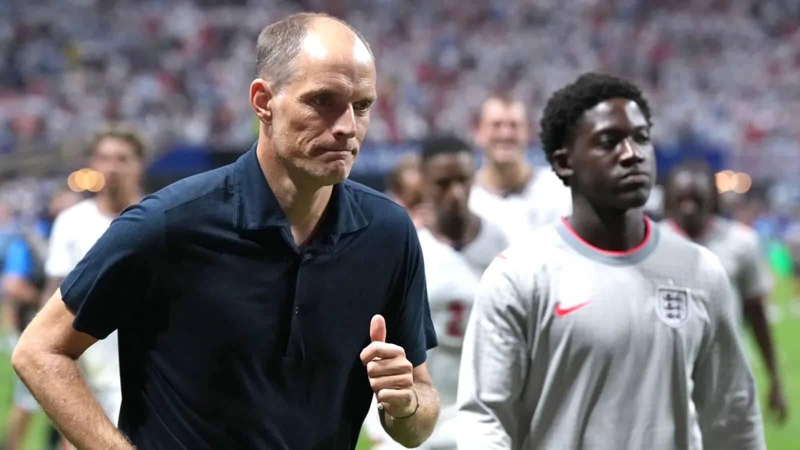 Coach and player walking off the pitch post-match Coach and player walking off the pitch post-match