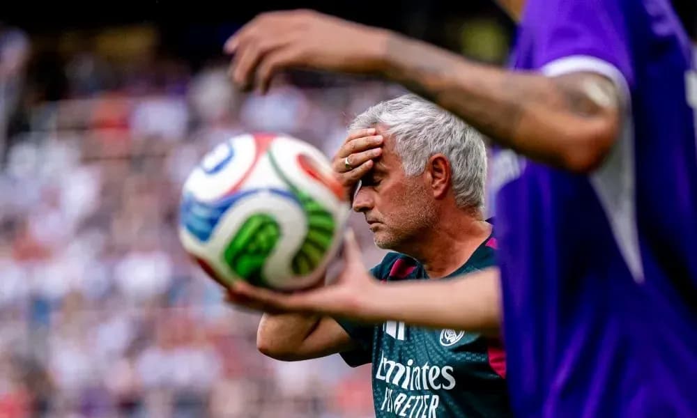 Coach holding head with soccer ball in foreground Coach holding head with soccer ball in foreground