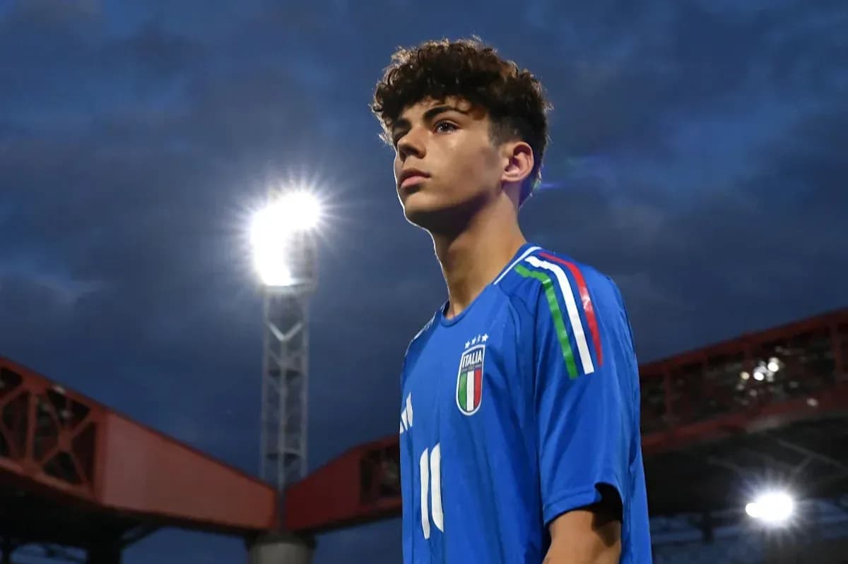 Player in blue Italy jersey under stadium lights Player in blue Italy jersey under stadium lights