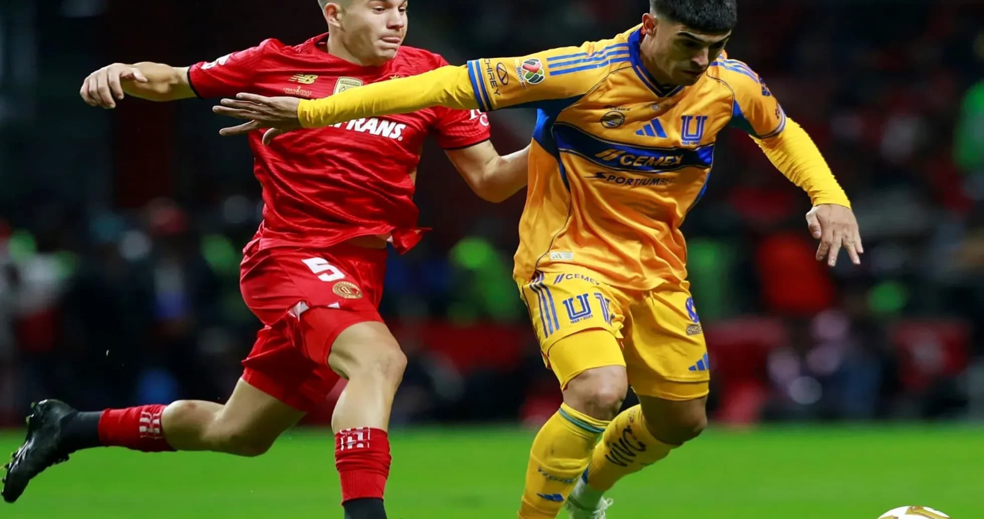Toluca player challenges Tigres UANL player for ball Toluca player challenges Tigres UANL player for ball