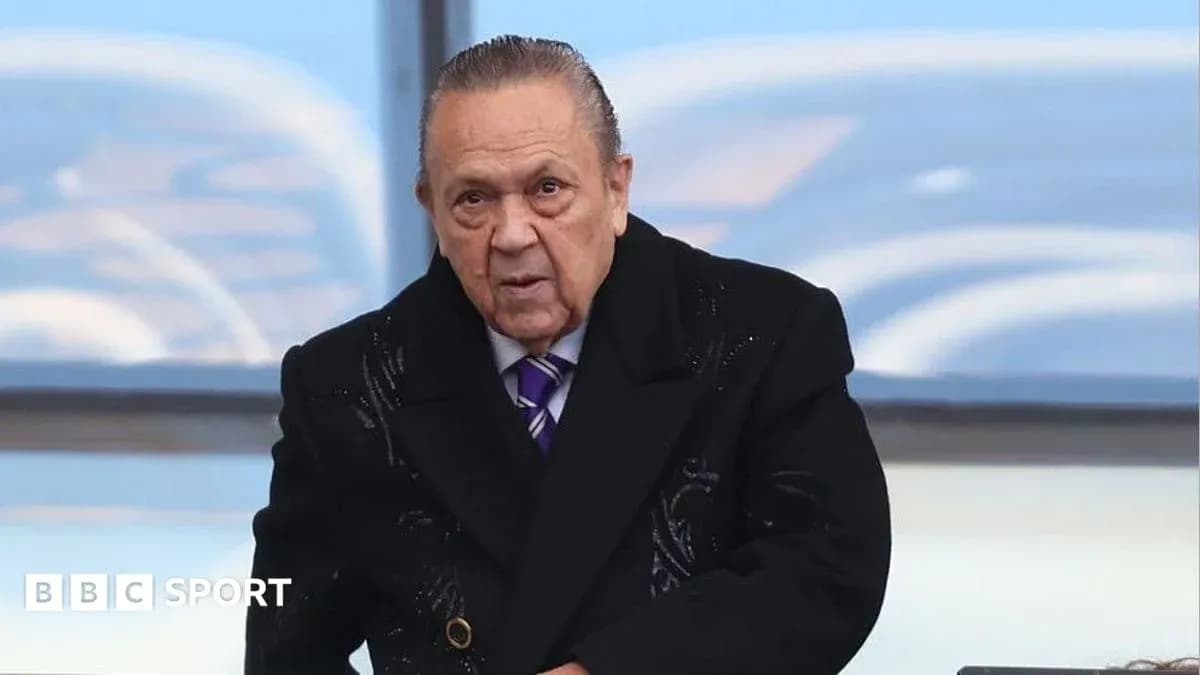 Man in black coat at a sports venue Man in black coat at a sports venue