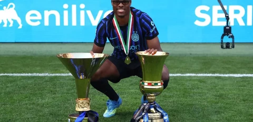 Player celebrating with two trophies after victory Player celebrating with two trophies after victory