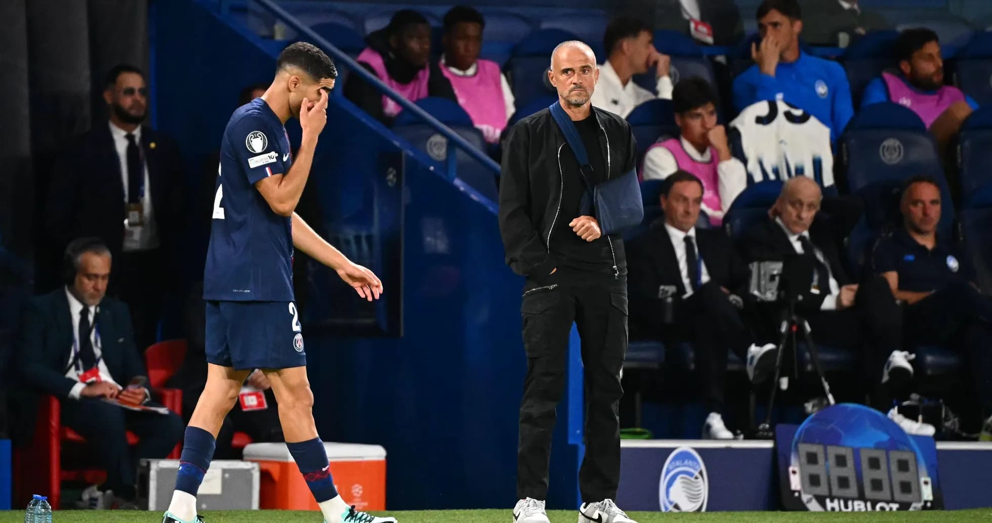 Player walking off field with coach observing Player walking off field with coach observing