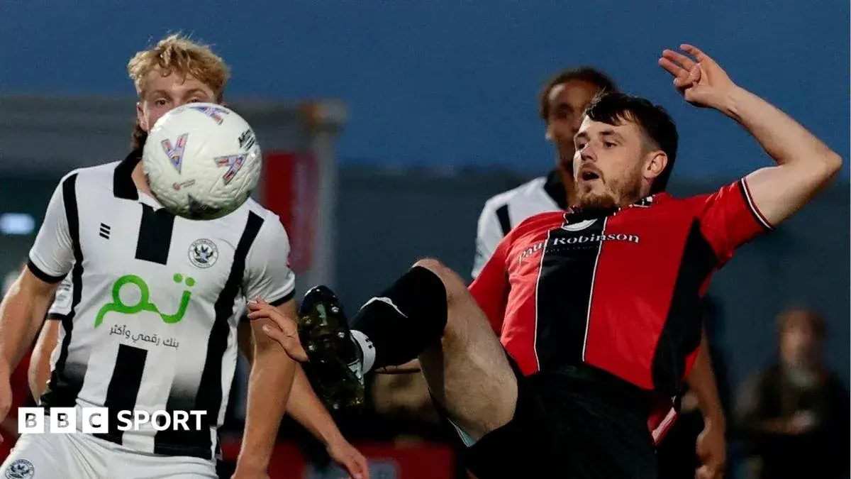 Player in red shirt falling while contesting ball Player in red shirt falling while contesting ball
