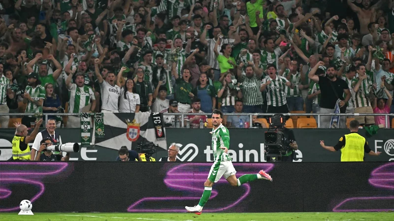 Player celebrating a goal with cheering fans behind Player celebrating a goal with cheering fans behind