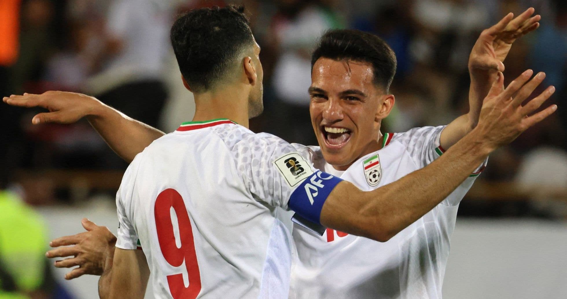 Two Iranian players celebrating a goal together Two Iranian players celebrating a goal together