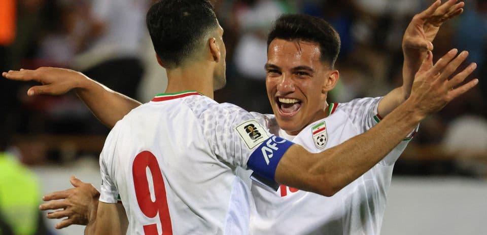 Two Iranian players celebrating a goal together Two Iranian players celebrating a goal together