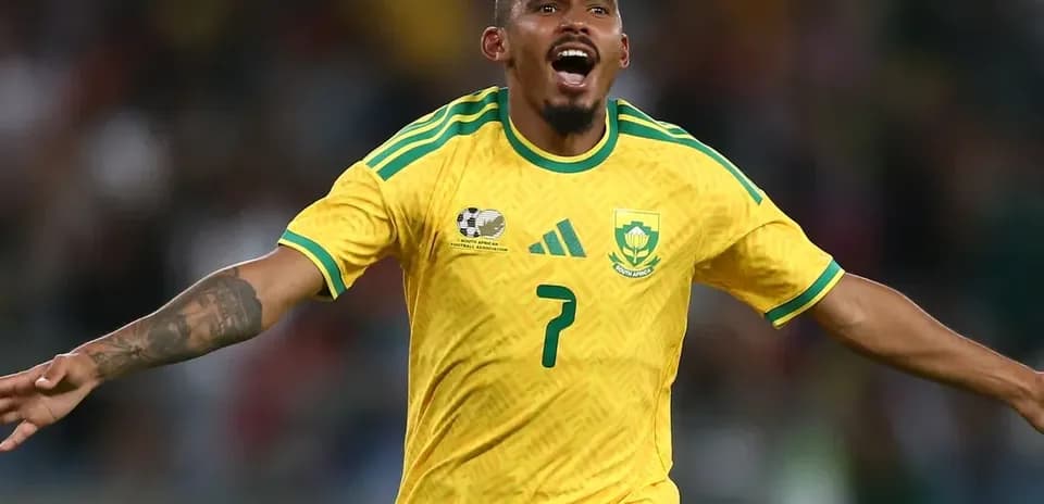 Player celebrating goal in yellow South Africa jersey Player celebrating goal in yellow South Africa jersey