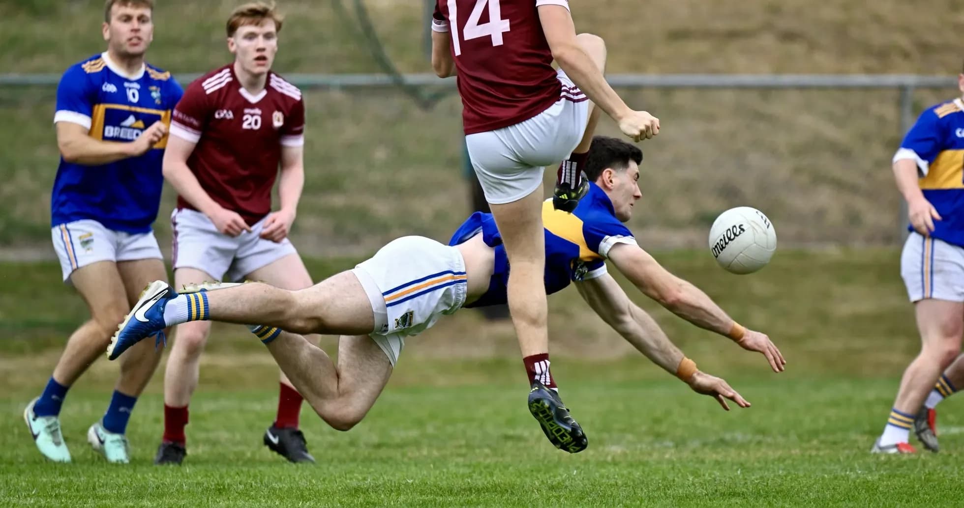 Player diving for the ball during Gaelic football match Player diving for the ball during Gaelic football match