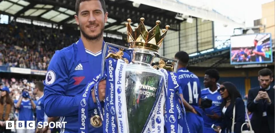 Player holding Premier League trophy on pitch Player holding Premier League trophy on pitch