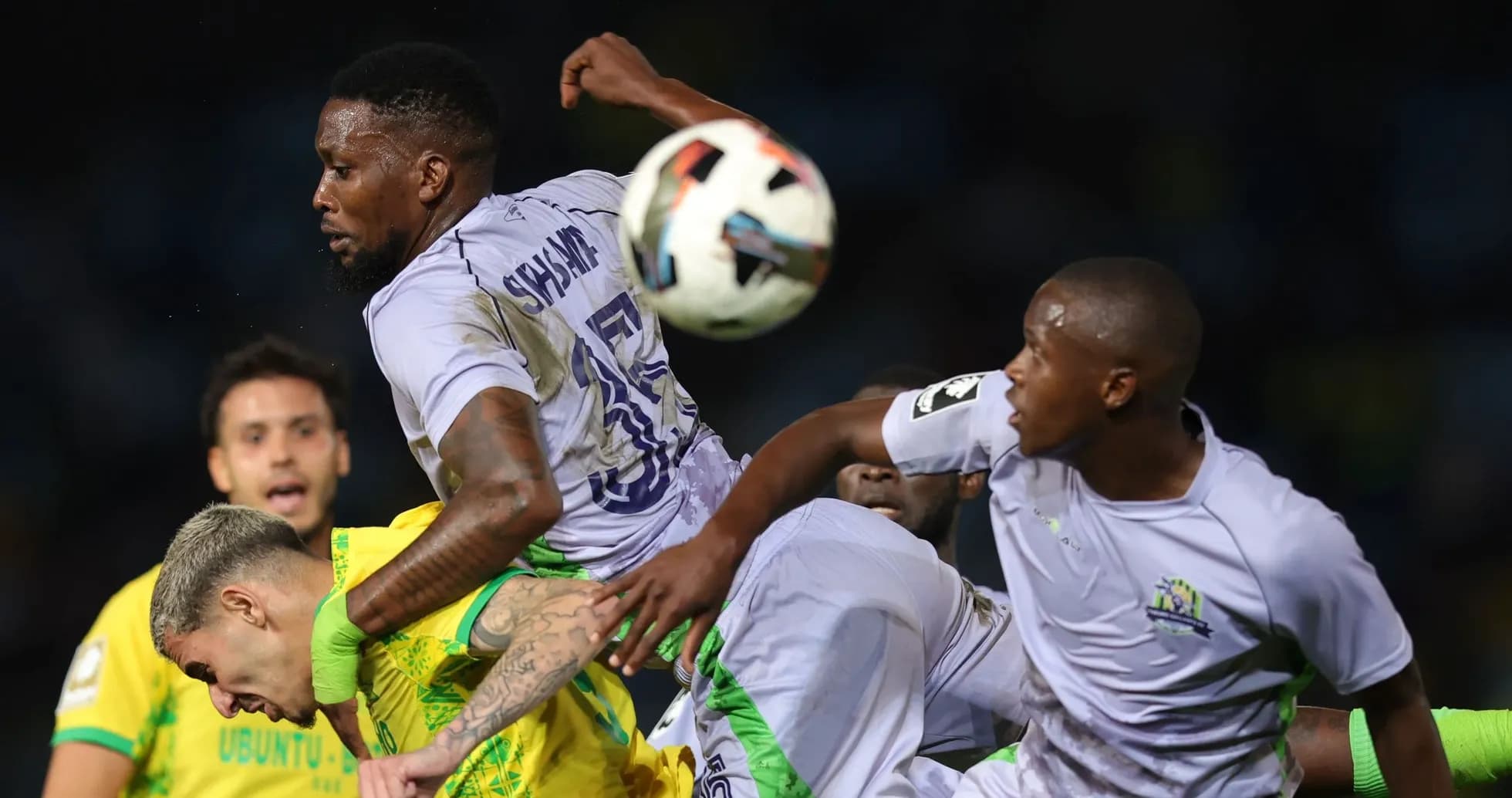 Players contesting the ball during a football match Players contesting the ball during a football match