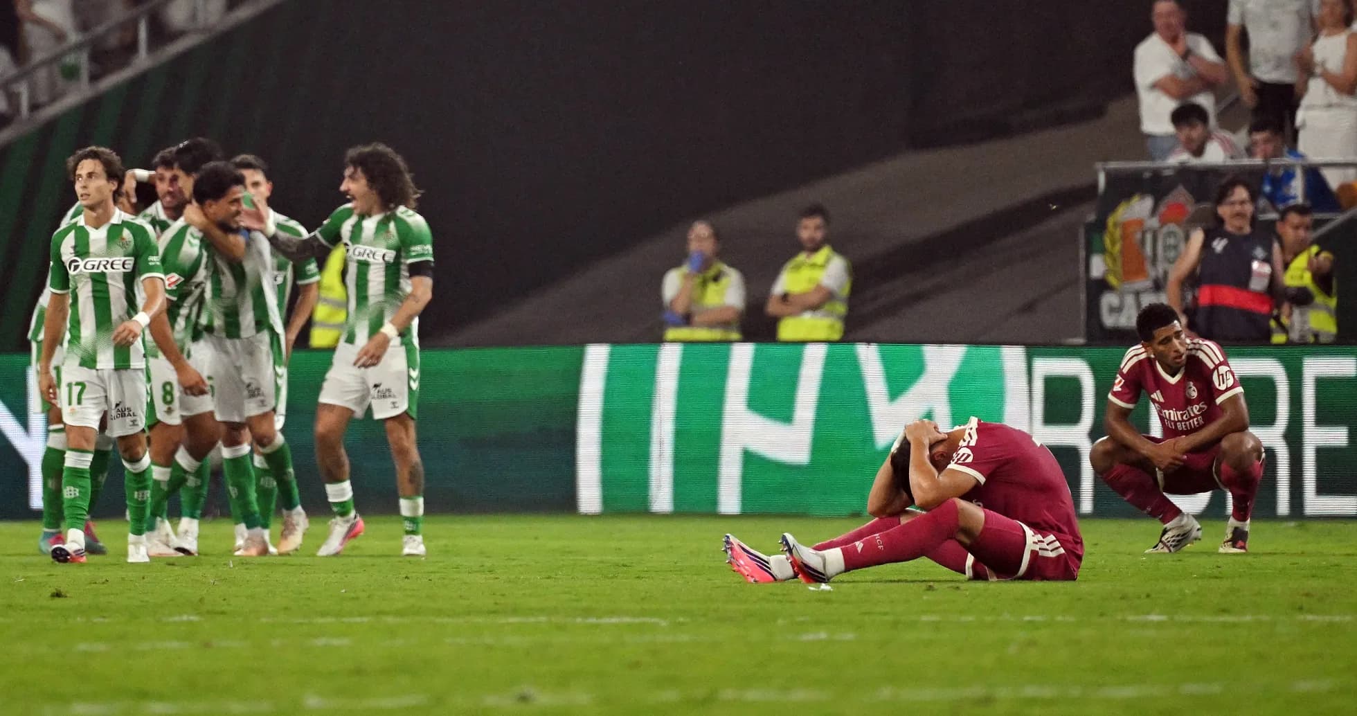Players celebrating a goal while opponents react in despair Players celebrating a goal while opponents react in despair