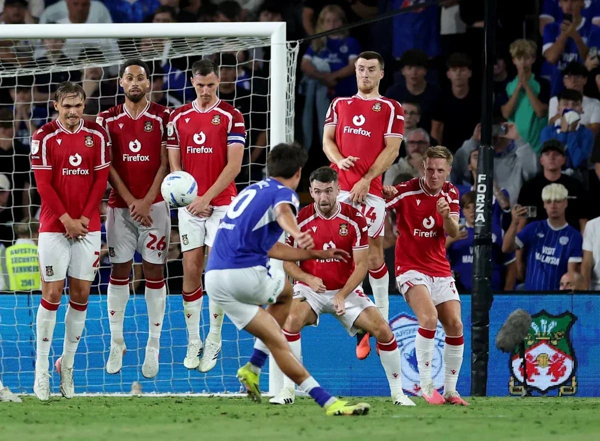 Player taking a free kick against defensive wall Player taking a free kick against defensive wall
