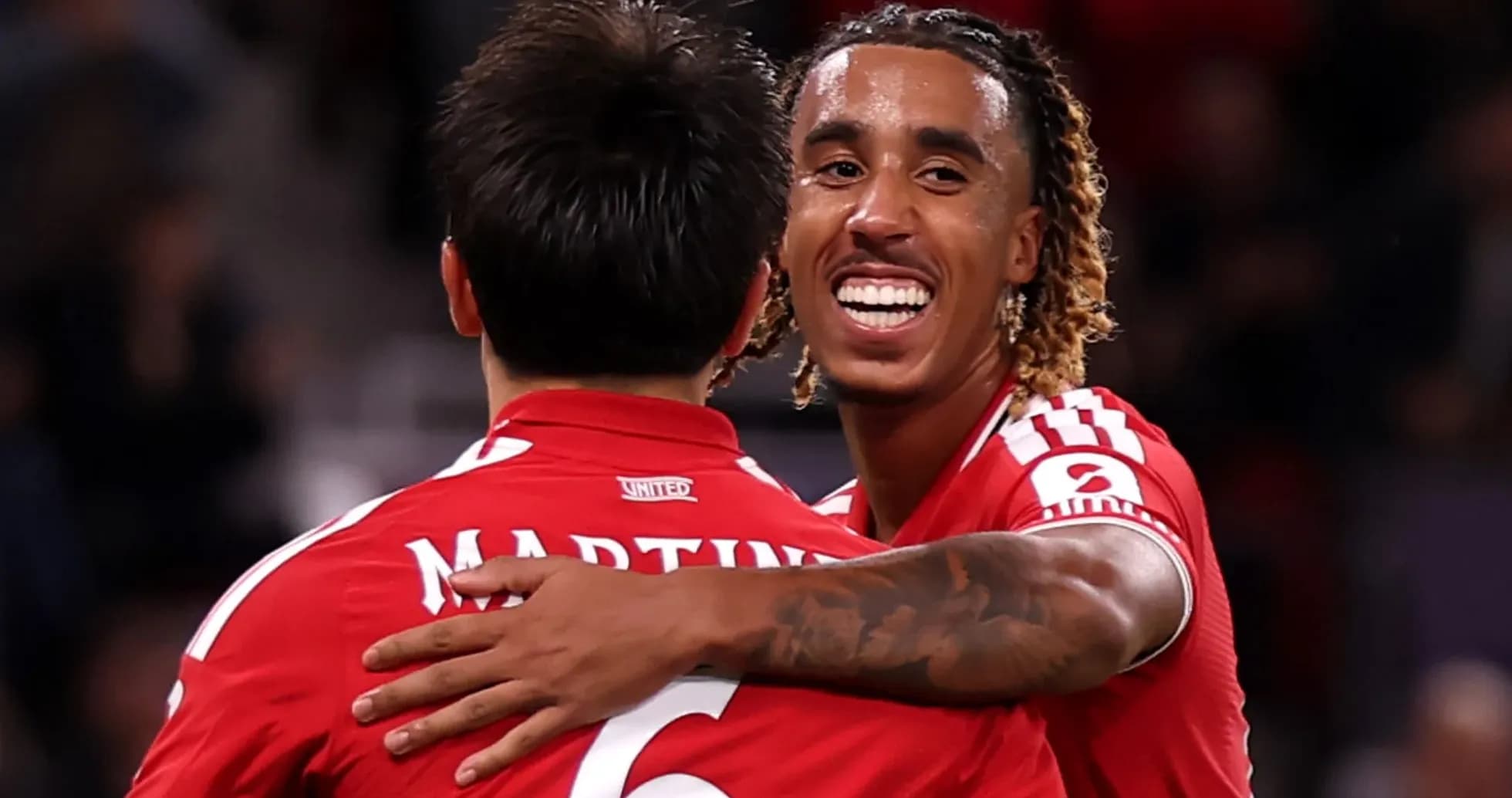 Two players celebrating a goal in red jerseys Two players celebrating a goal in red jerseys