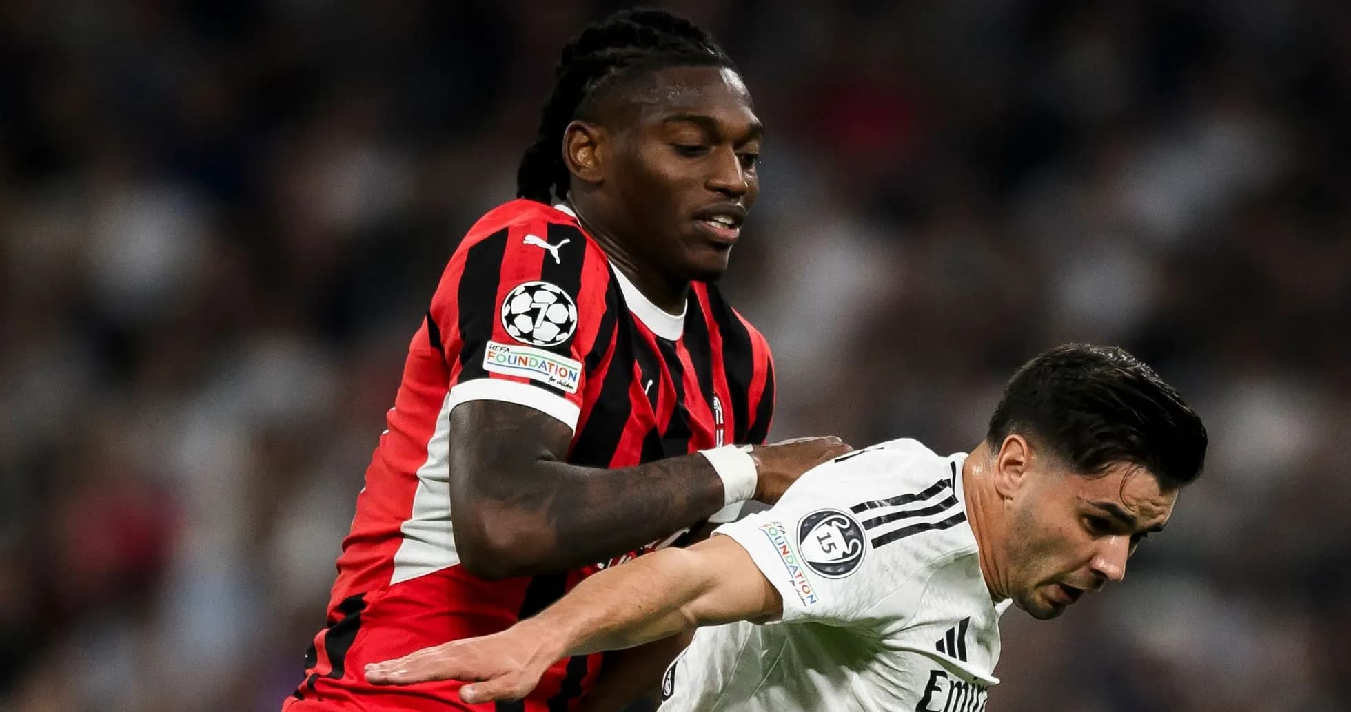 Player in red and black jersey tackling opponent in white Player in red and black jersey tackling opponent in white