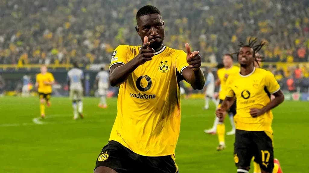 Player celebrating a goal with teammates in stadium Player celebrating a goal with teammates in stadium