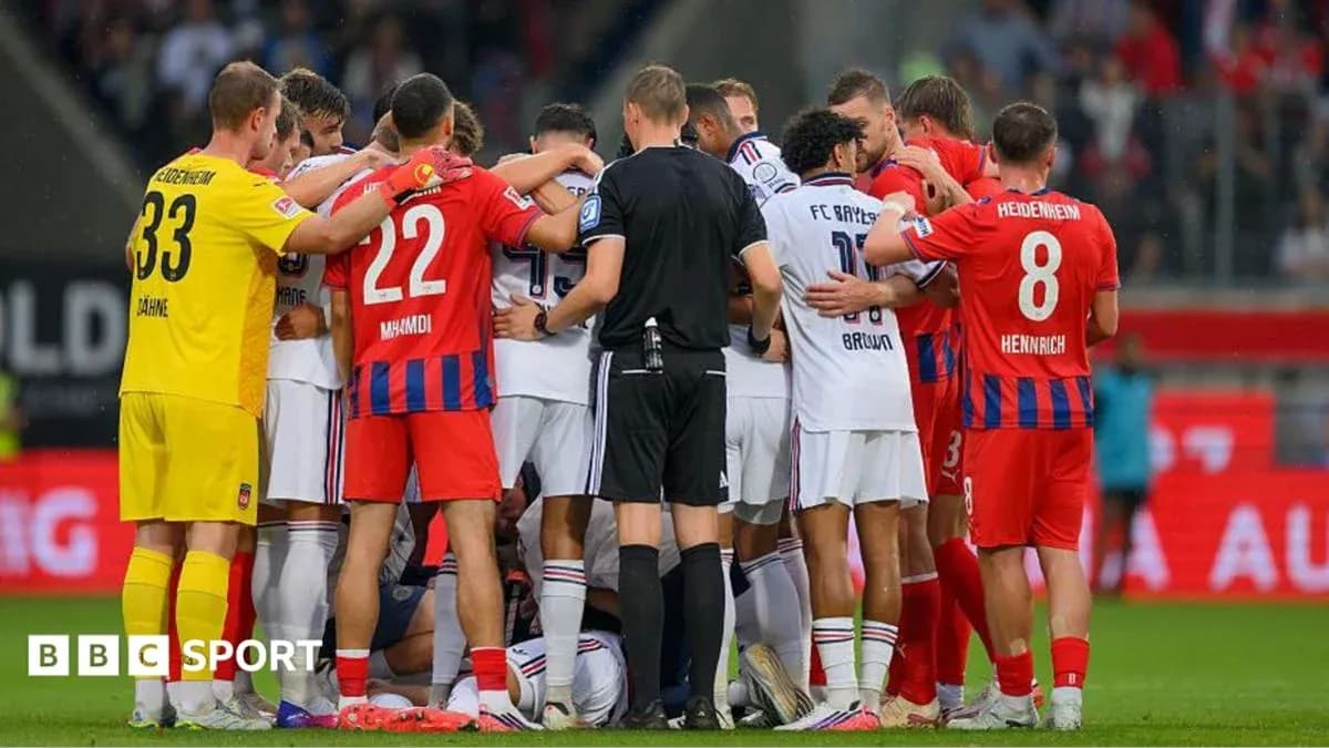 Players from both teams gathering around an injured player Players from both teams gathering around an injured player