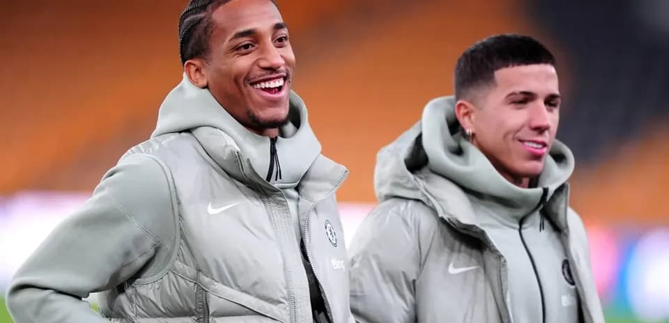 Two players smiling in training jackets on field Two players smiling in training jackets on field
