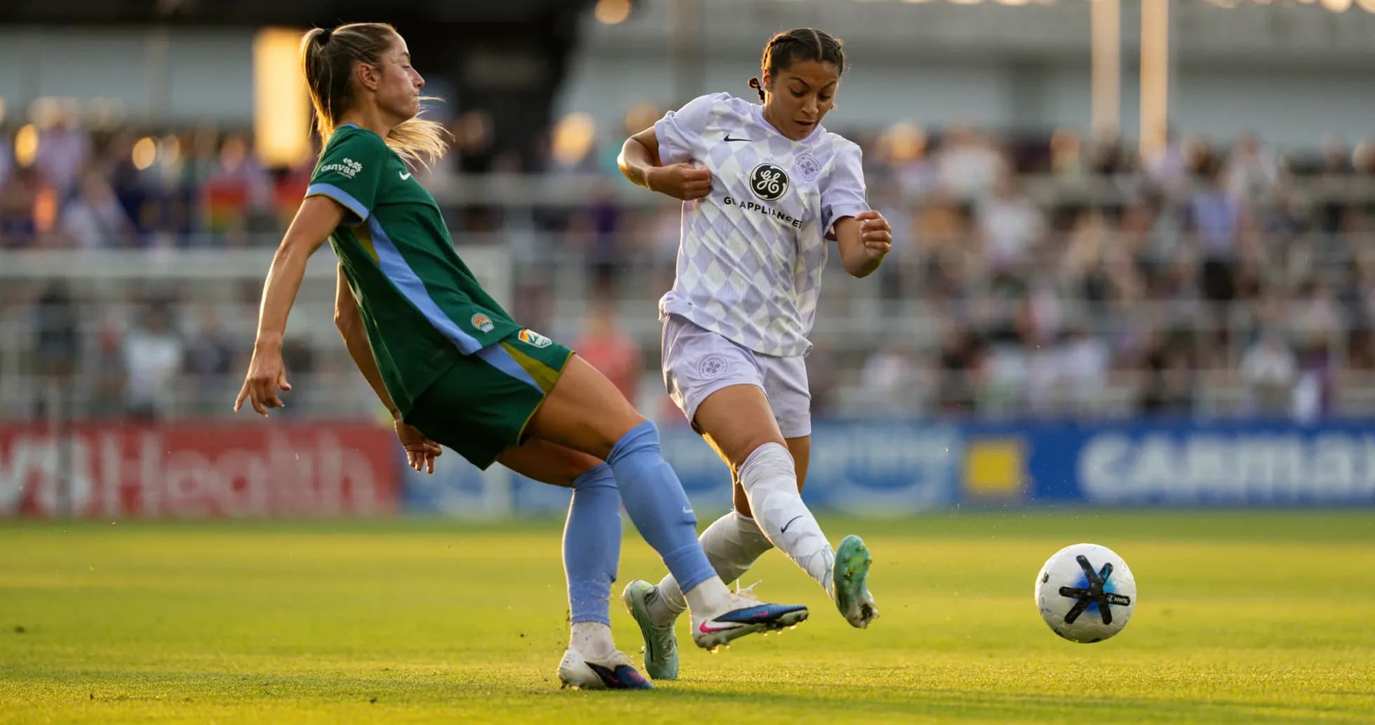 Two players competing for the ball in NWSL match Two players competing for the ball in NWSL match