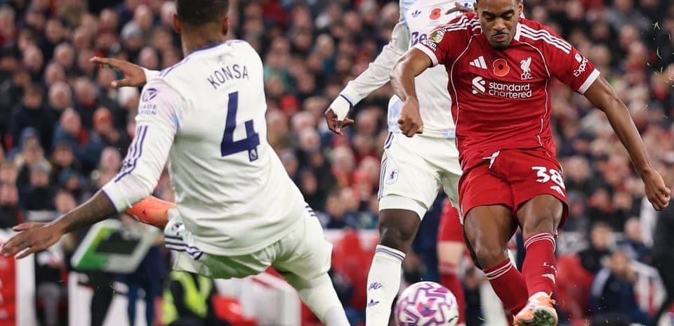 Aston Villa player challenges Liverpool forward during match Aston Villa player challenges Liverpool forward during match