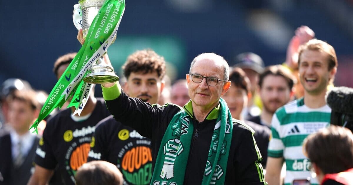 Coach holding trophy with team celebrating behind Coach holding trophy with team celebrating behind