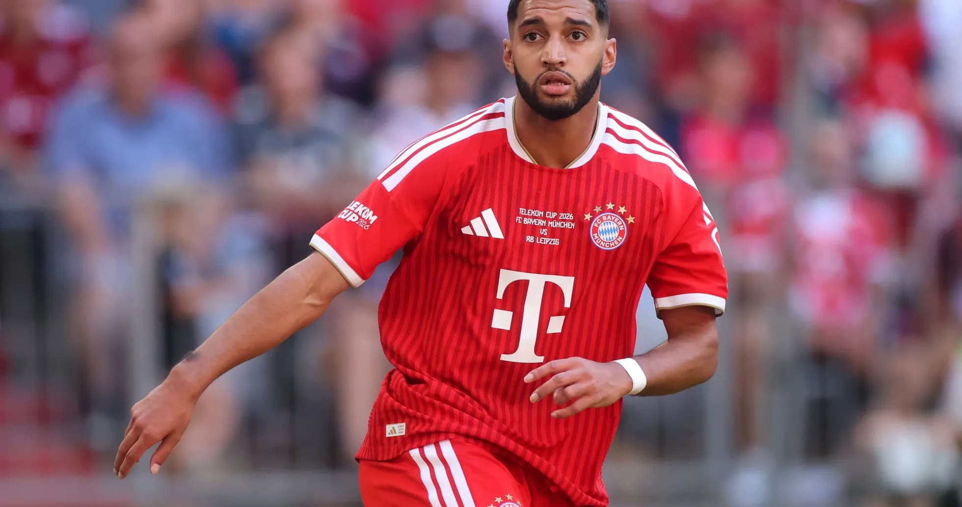 Player in red Bayern Munich kit running on field Player in red Bayern Munich kit running on field