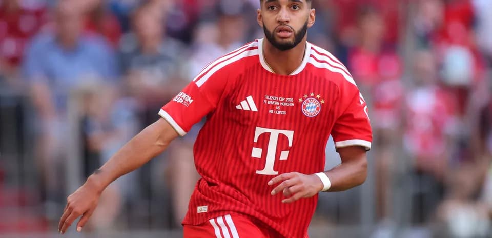Player in red Bayern Munich kit running on field Player in red Bayern Munich kit running on field