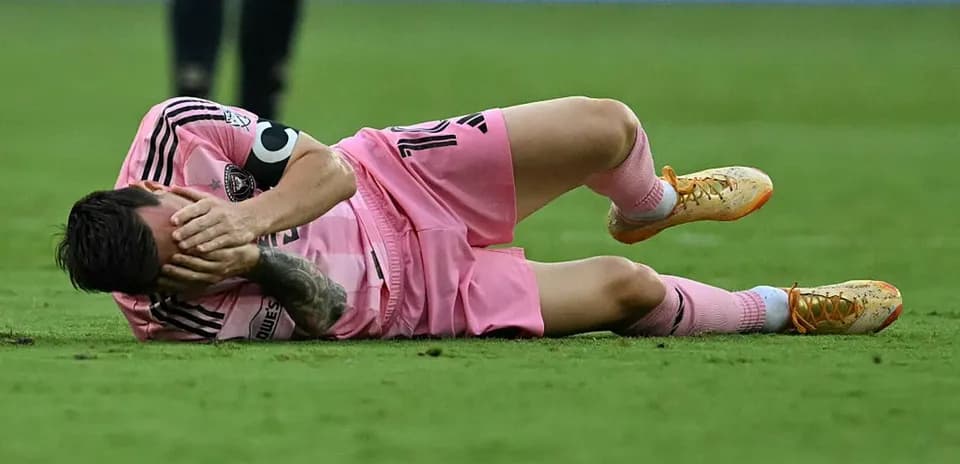Player lying on the ground holding face in pain Player lying on the ground holding face in pain