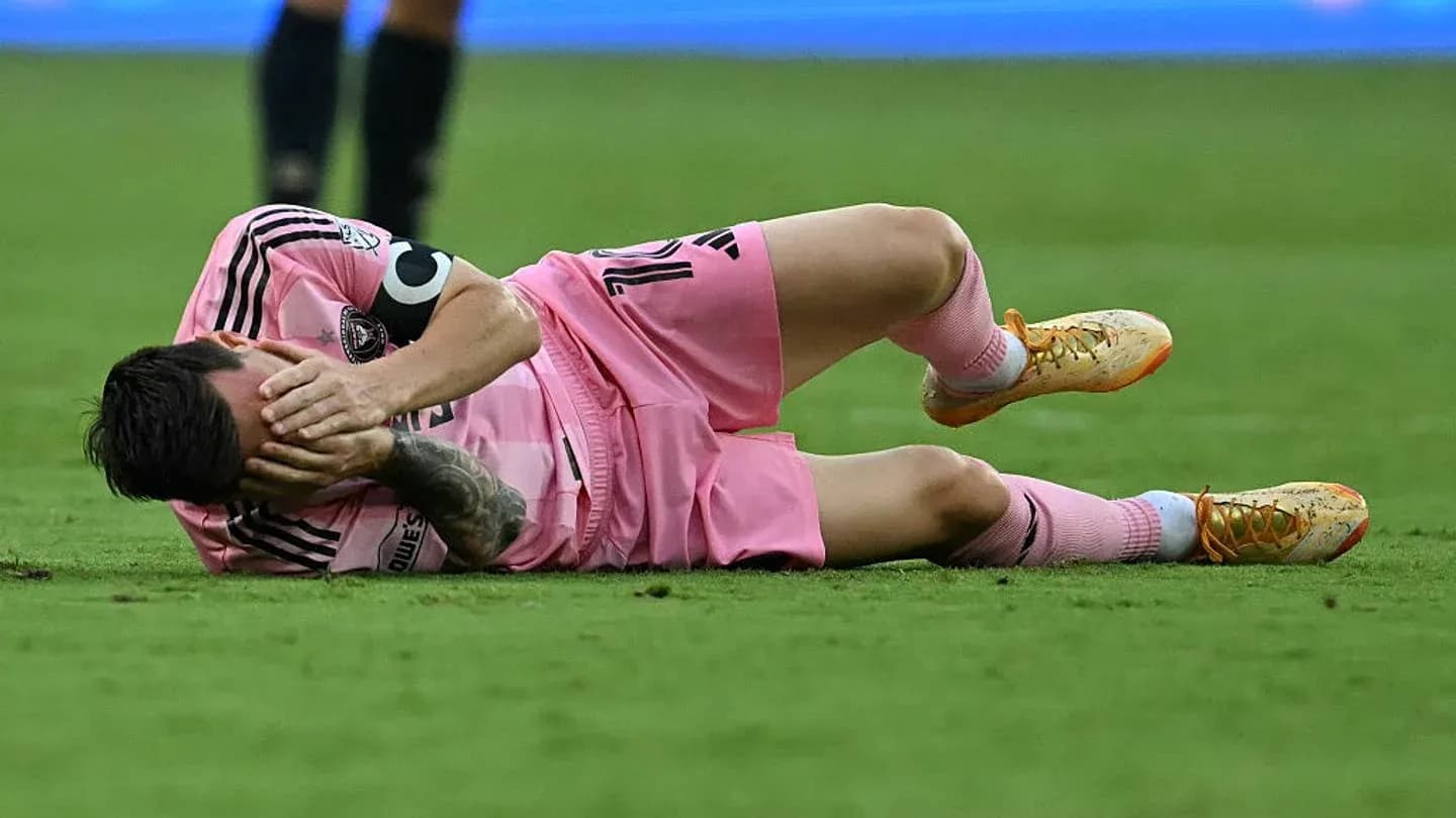 Player lying on the ground holding face in pain Player lying on the ground holding face in pain