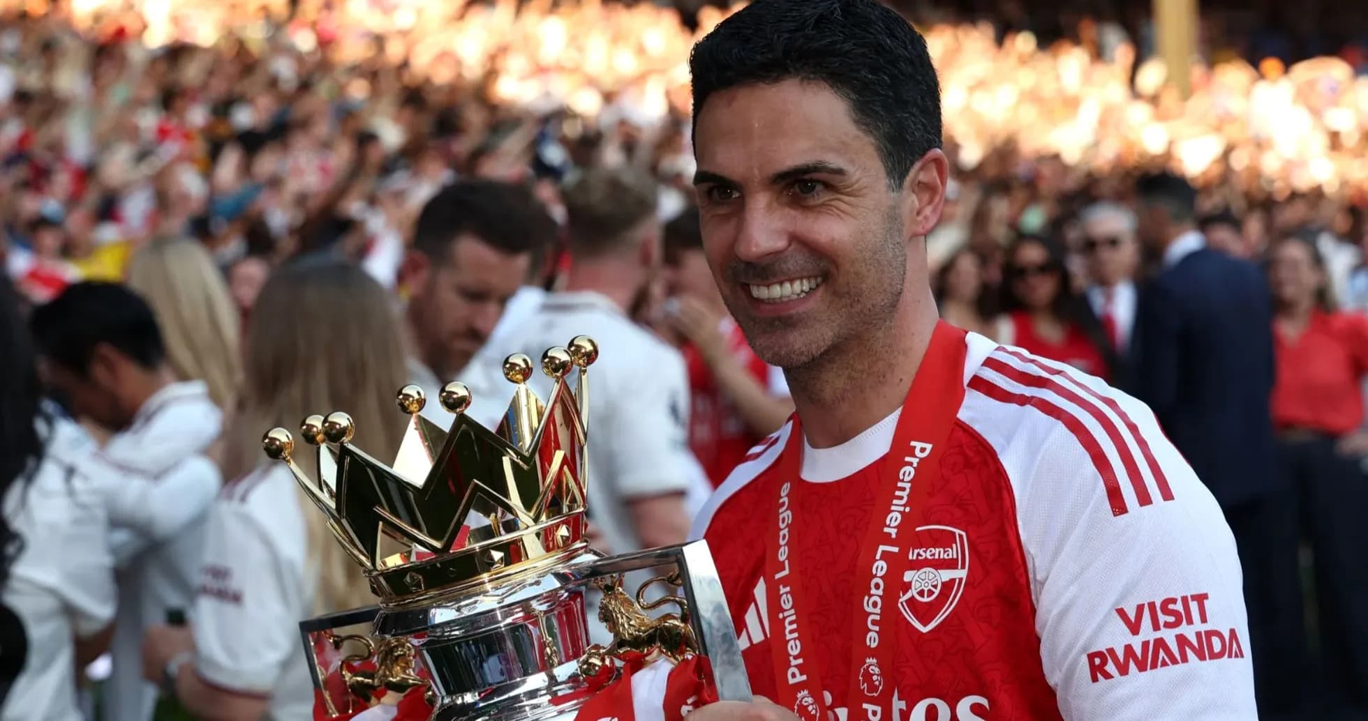 Arsenal manager holding Premier League trophy after victory Arsenal manager holding Premier League trophy after victory