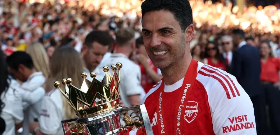 Arsenal manager holding Premier League trophy after victory Arsenal manager holding Premier League trophy after victory