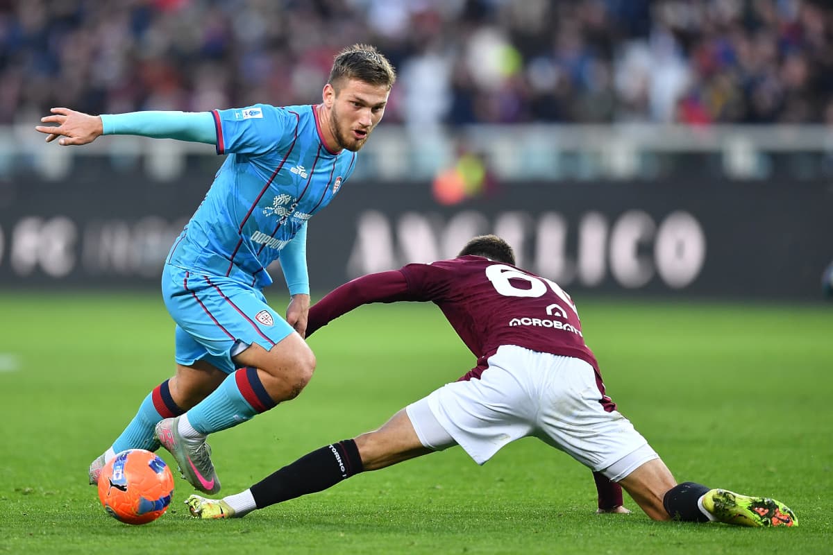 Cagliari player evading tackle during Serie A match Cagliari player evading tackle during Serie A match
