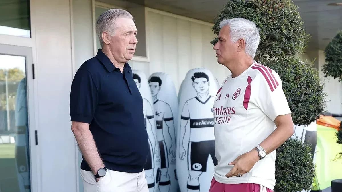 Two coaches conversing near training equipment Two coaches conversing near training equipment