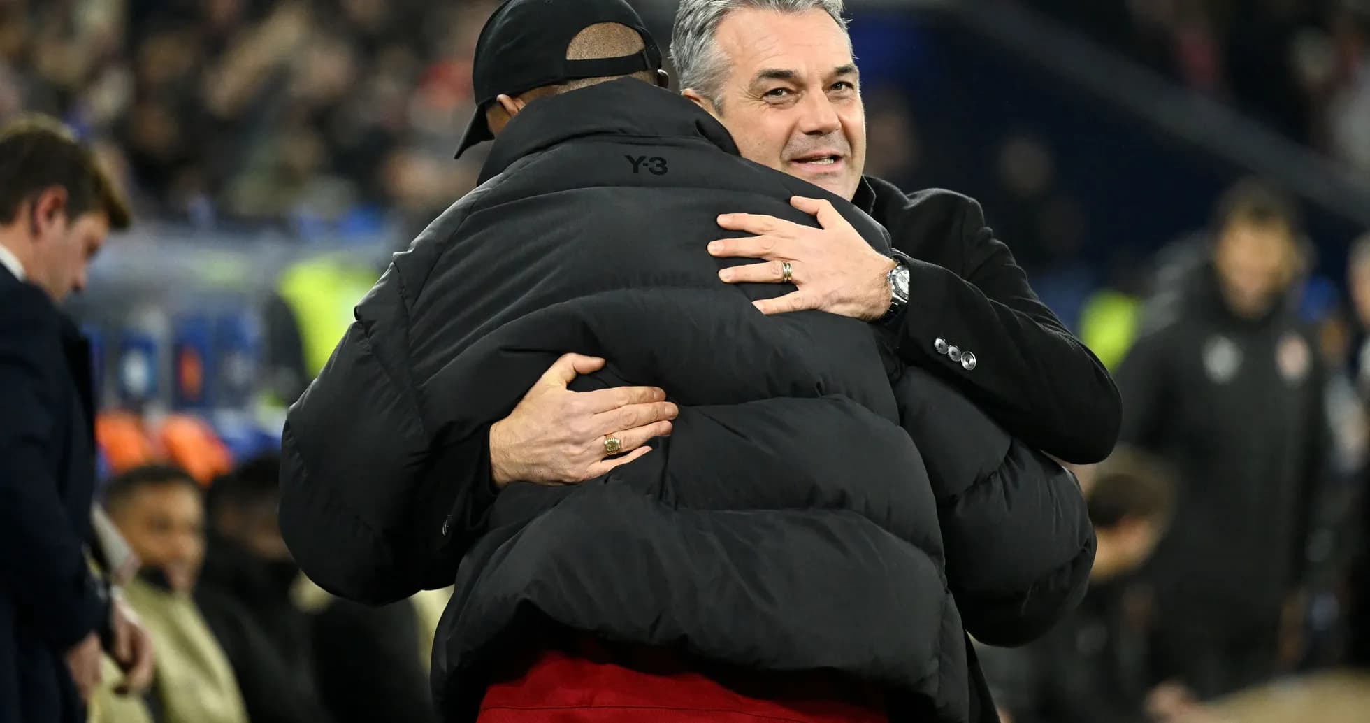 Two coaches embracing on the sideline Two coaches embracing on the sideline