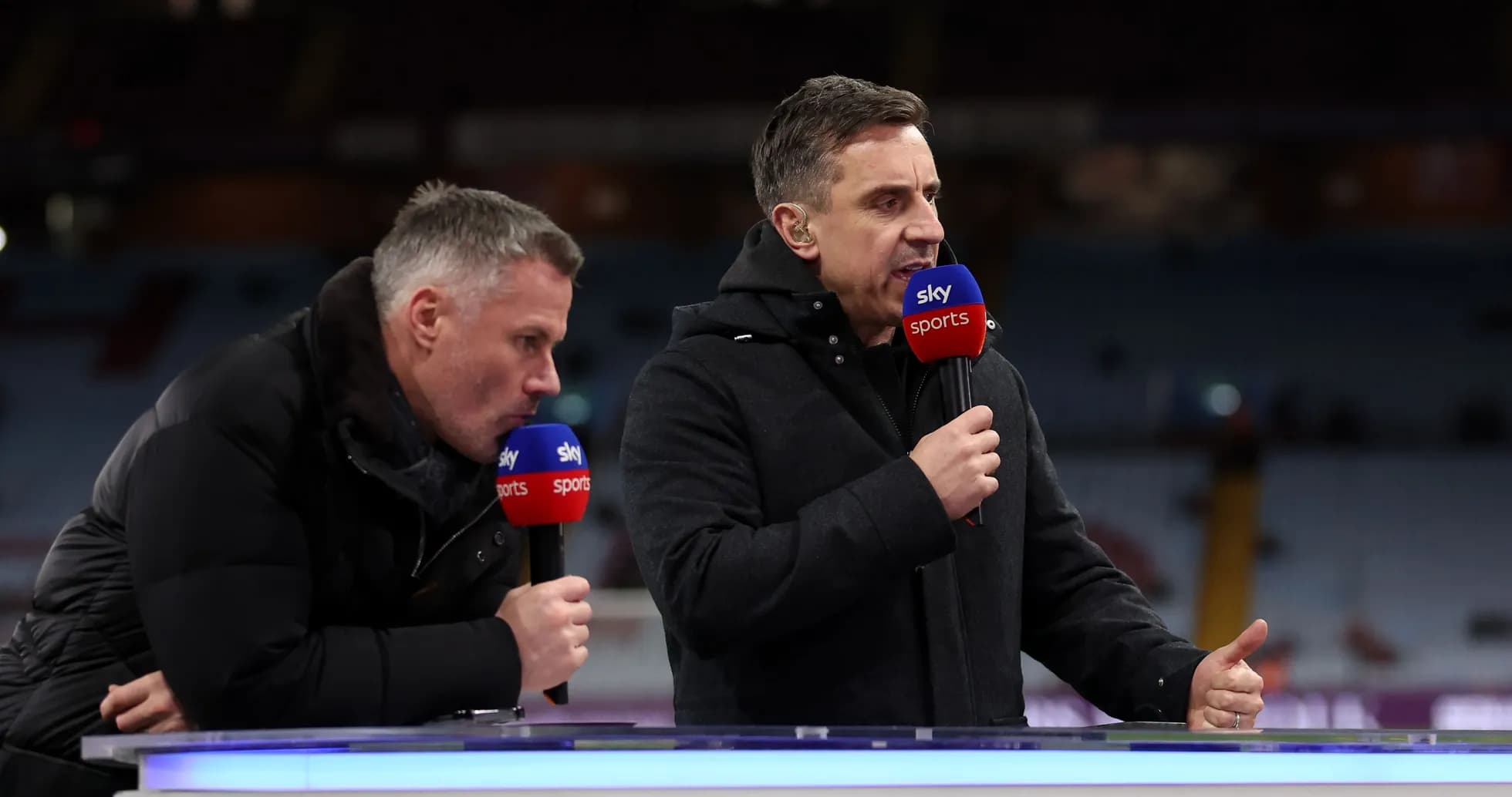 Two sports commentators speaking at a broadcast desk Two sports commentators speaking at a broadcast desk